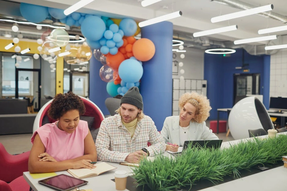 Různorodý tým projektových manažerů diskutuje nad plány v moderní kanceláři.